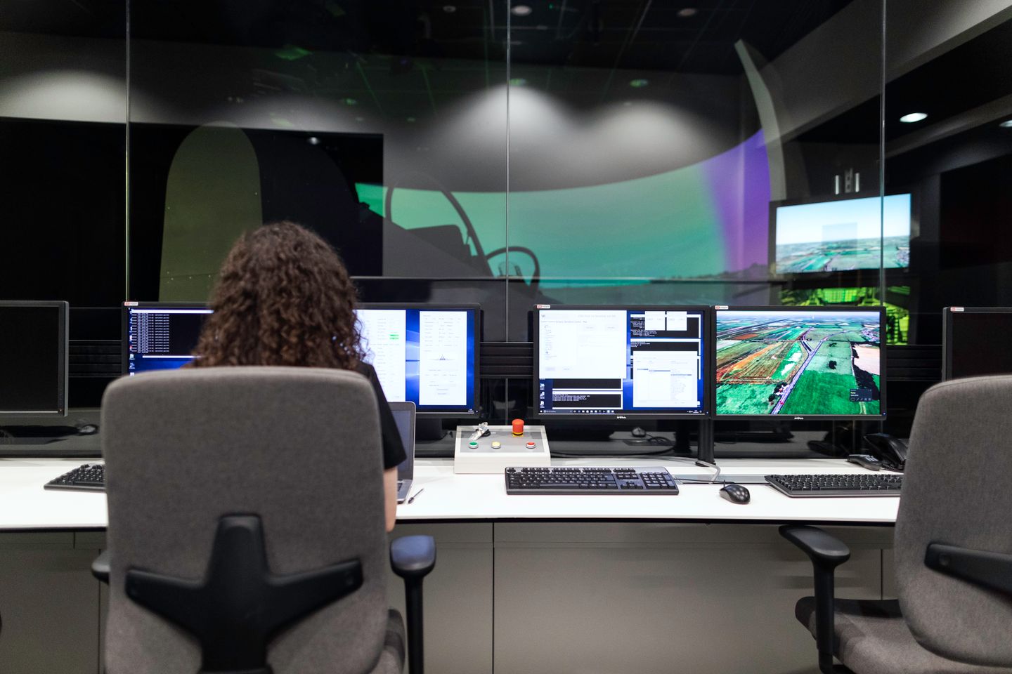 Operator reviewing technical information across multiple monitors