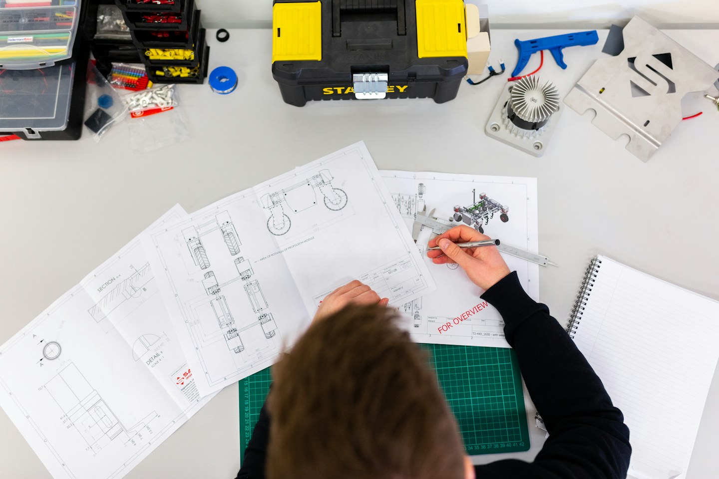 Engineer checking technical drawings at a workshop table